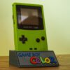Photo d'une Game Boy Color Verte Fluo restaurée sur son socle, vue de 3/4