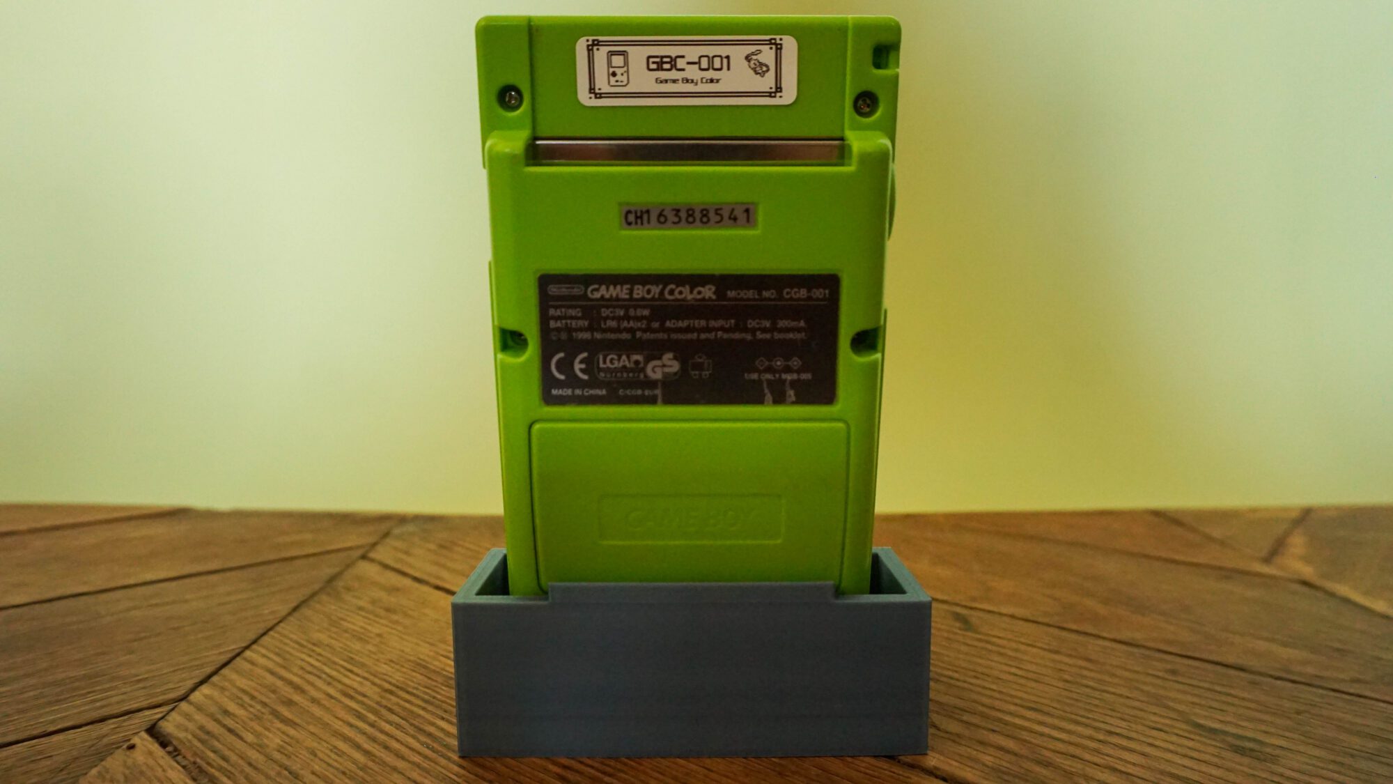 Photo d'une Game Boy Color Verte Fluo sur son socle, vue de dos