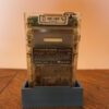 Photo d'une Game Boy Color Transparente sur son socle, vue de dos
