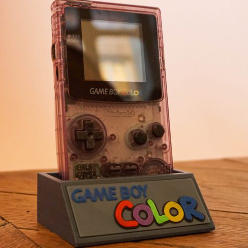 Photo d'une Game Boy Color Transparente/Violette restaurée sur son socle, vue de 3/4