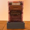 Photo d'une Game Boy Color Transparente/Violette sur son socle, vue de dos