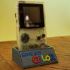 Photo d'une Game Boy Color Transparente restaurée sur son socle, vue de 3/4