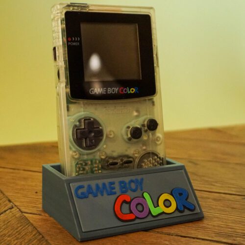 Photo d'une Game Boy Color Transparente restaurée sur son socle, vue de 3/4