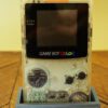 Photo d'une Game Boy Color Transparente sur son socle, vue de face