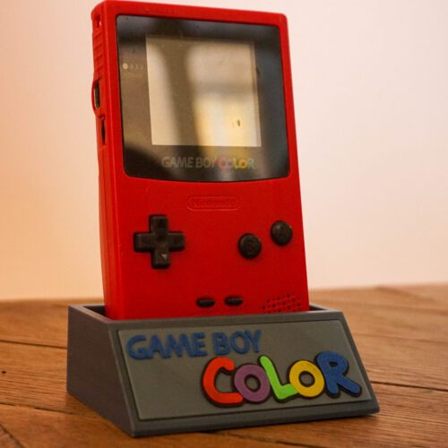 Photo d'une Game Boy Color Rouge "Berry" sur son socle, vue de 3/4