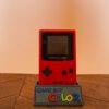 Photo d'une Game Boy Color Rouge "Berry" sur son socle, vue de face