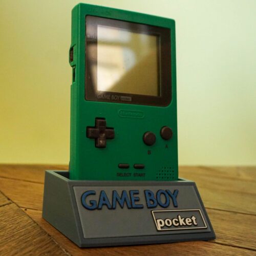 Photo d'une Game Boy Pocket Verte sur son socle, vue de 3/4