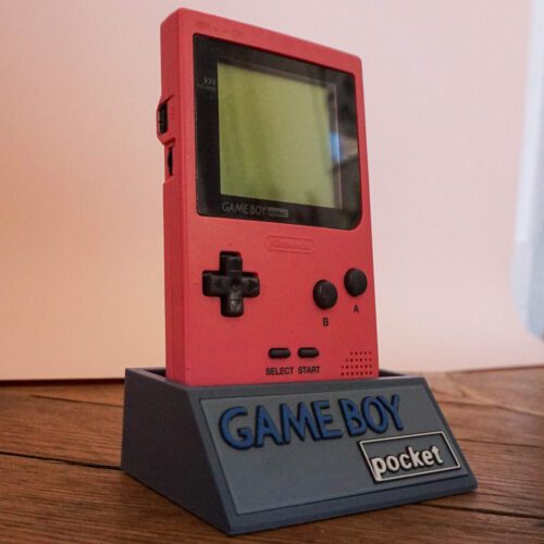 Photo d'une Game Boy Pocket Rose restaurée sur son socle, vue de 3/4