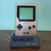 Photo d'une Game Boy Pocket Or sur son socle, vue de face
