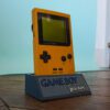 Photo d'une Game Boy Pocket Jaune sur son socle, vue de 3/4