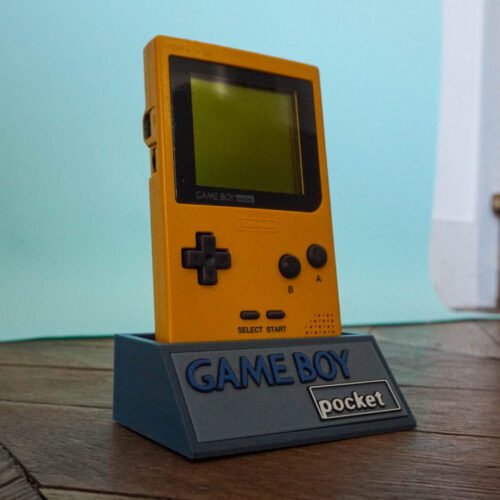 Photo d'une Game Boy Pocket Jaune sur son socle, vue de 3/4