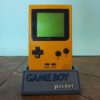Photo d'une Game Boy Pocket Jaune sur son socle, vue de face