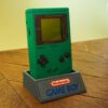 Photo d'une Game Boy Classic Verte restaurée sur son socle, vue de 3/4
