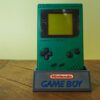 Photo d'une Game Boy Classic Verte sur son socle, vue de face