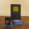 Photo d'une Game Boy Classic Noire sur son socle, vue de face, avec le jeu Zelda Link's Awakening DX
