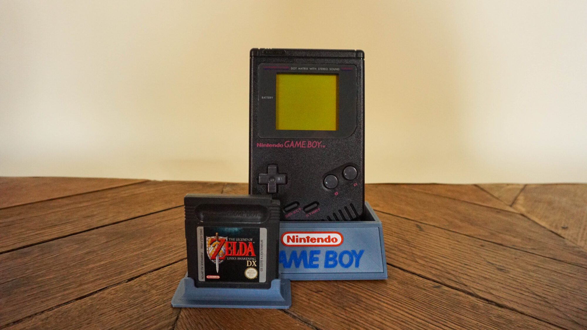 Photo d'une Game Boy Classic Noire sur son socle, vue de face, avec le jeu Zelda Link's Awakening DX