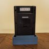 Photo d'une Game Boy Classic Noire sur son socle, vue de dos
