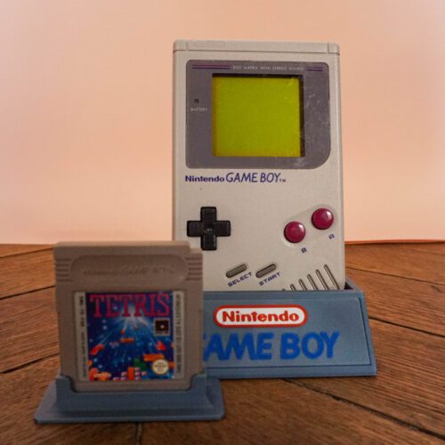 Photo d'une Game Boy Classic Grise sur son socle, vue de face, avec le jeu Tetris