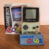 Photo d'une Game Boy Color Transparente sur son socle, vue de face, avec sa boîte