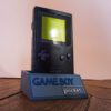 Photo d'une Game Boy Pocket Noire sur son socle, vue de 3/4