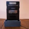 Photo d'une Game Boy Pocket Noire sur son socle, vue de dos