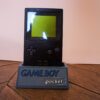 Photo d'une Game Boy Pocket Noire sur son socle, vue de face