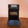 Photo d'une Game Boy Pocket Noire sur son socle, vue de dos