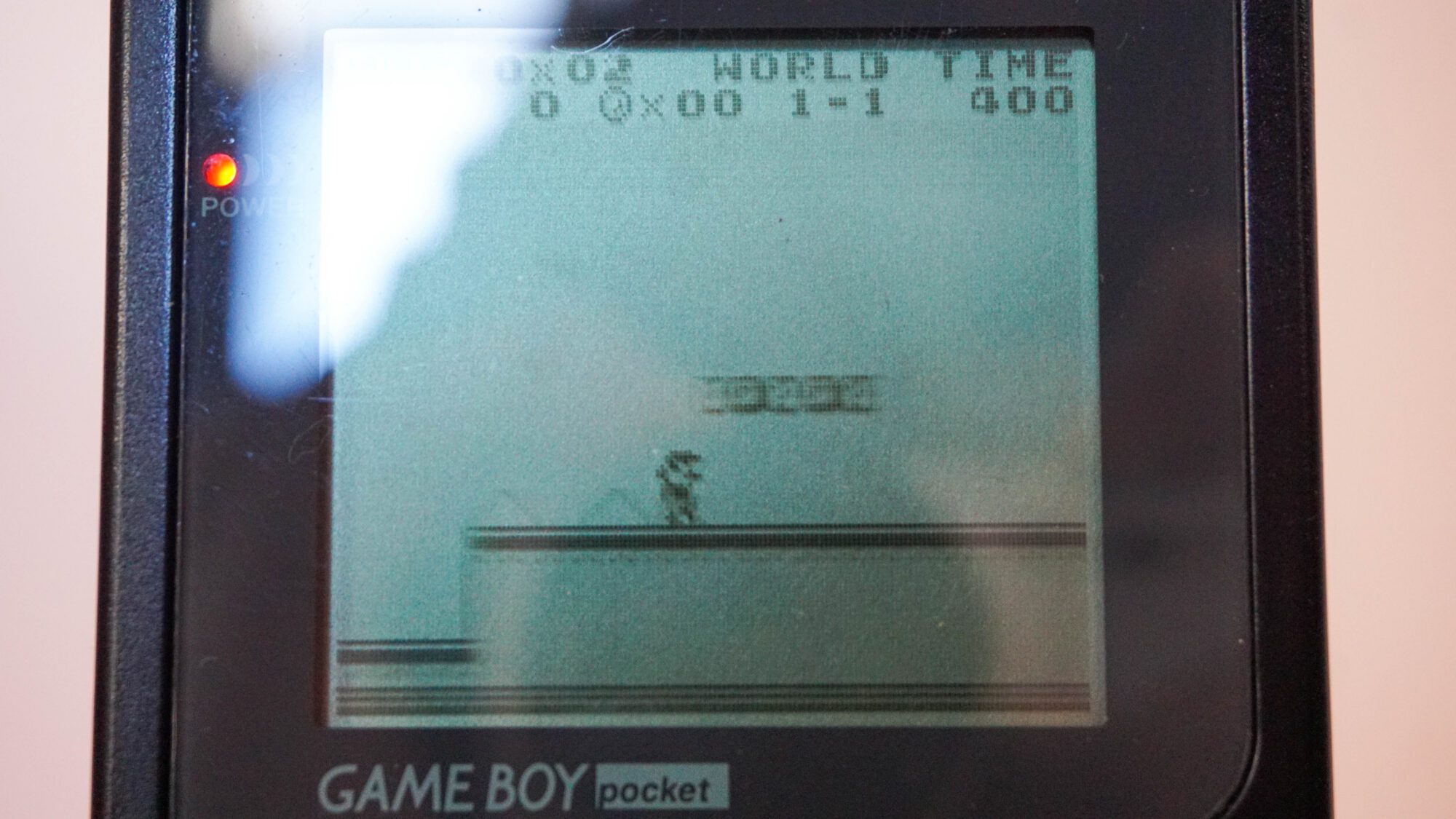 Photo d'une Game Boy Pocket Noire, vue de l'écran qui fonctionne